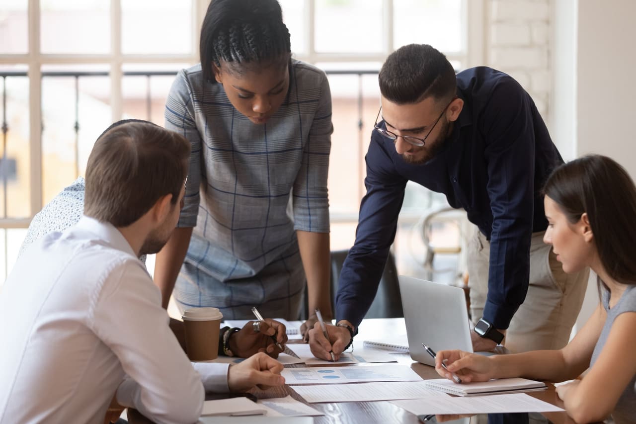 Équipe réunie autour d’une table de travail couverte de documents