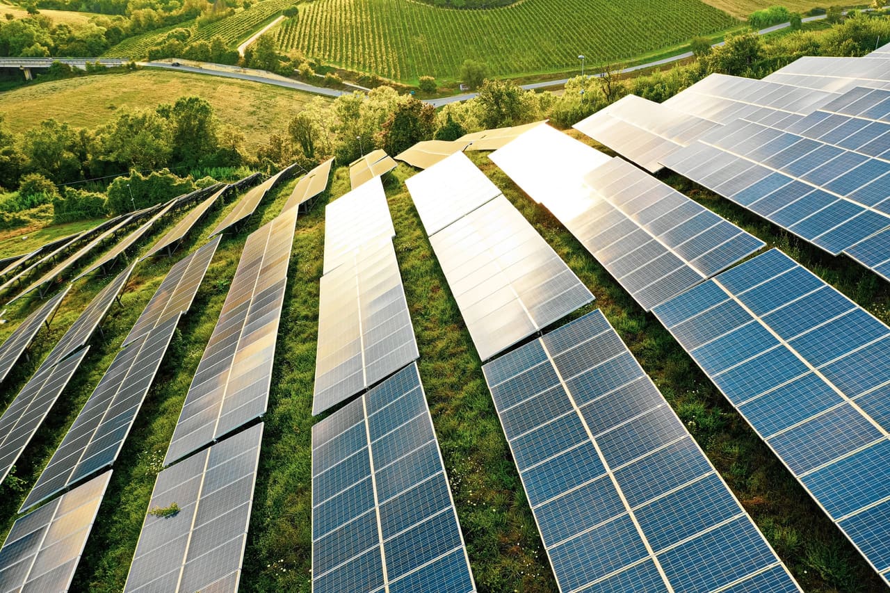 Rangées de panneaux photovoltaïques sur une colline verdoyante